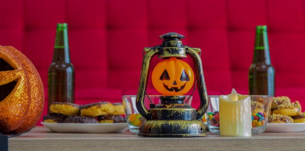 Abóbora laranja na noite de Halloween com velas e doces Beber em celebração do Halloween