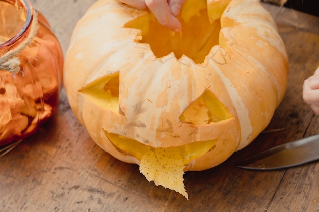 Abóbora laranja pequena, jack-o-lantern na mesa de madeira