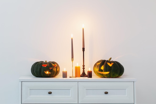 Abóbora preta de halloween com velas acesas no interior branco