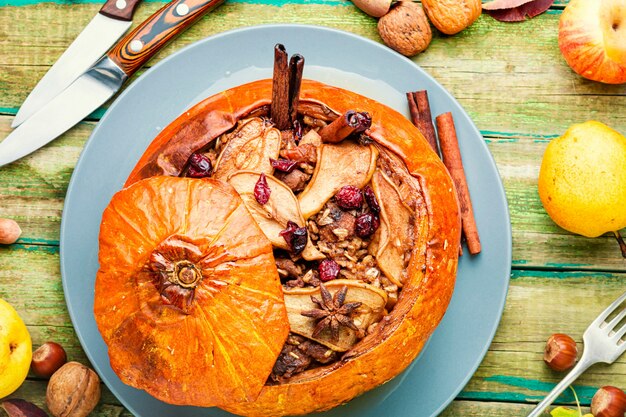 Abóbora recheada com granola e frutas secas na velha mesa de madeira