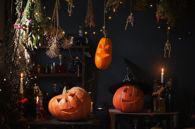 Abóboras de Halloween com luzes, velas acesas e poções mágicas na casa da bruxa