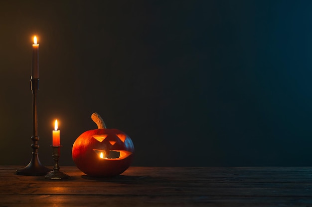 Abóboras de Halloween com velas acesas em fundo escuro