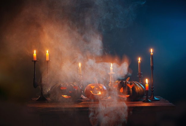 Abóboras de Halloween com velas acesas em fundo escuro