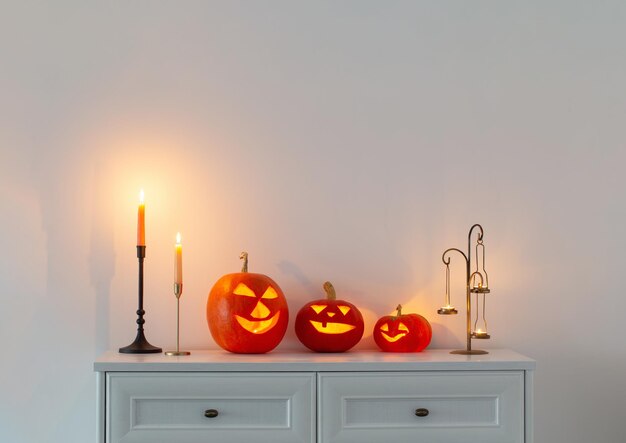 Abóboras de Halloween com velas acesas no interior branco