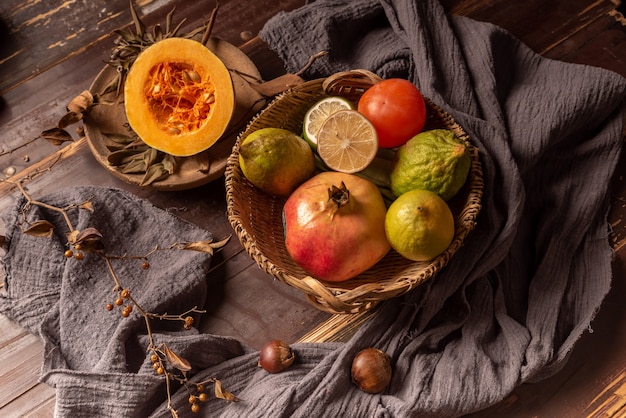 Abóboras e muitas outras cores e variedades de frutas e vegetais estão na mesa de grãos de madeira