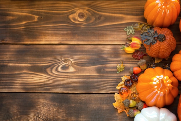 Abóboras laranja e brancas em uma mesa de madeira com maple amarelo de outono deixa bagas com copyspace humor de outono colheita de halloween decoração de casa de ação de graças