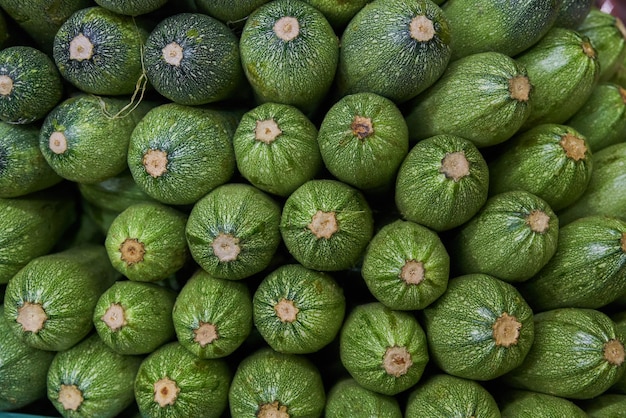 Abobrinha empilhada em uma prateleira para venda dentro de um mercado