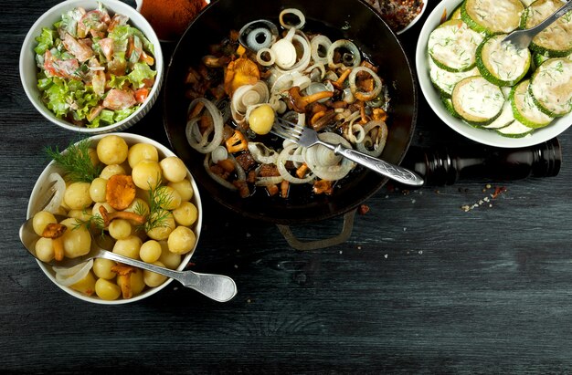 Abobrinha frita, batatas cozidas jovens com endro e cogumelos chanterelle fritos com cebola dourada