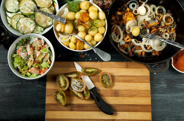 Abobrinha frita, batatas cozidas jovens com endro e cogumelos chanterelle fritos com cebola dourada