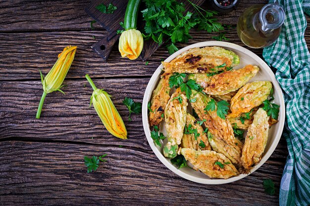 Abobrinha frita flores recheadas com ricota e ervas verdes. comida vegana. cozinha italiana. vista do topo