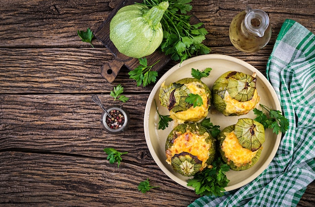 Abobrinha recheada com carne picada, queijo e ervas verdes. Assado no forno. Vista do topo