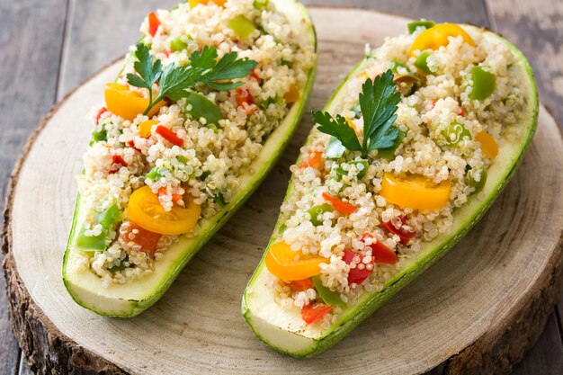 Abobrinha recheada com quinoa e legumes na mesa de madeira