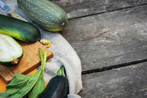 Abobrinha verde cultivada local em um fundo de madeira com lugar para texto