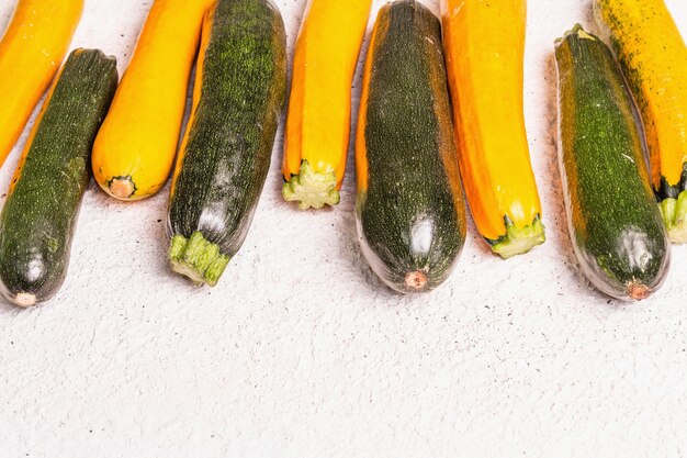 Abobrinhas frescas sortidas. Colheita de vegetais maduros em um fundo claro de gesso, copie o espaço