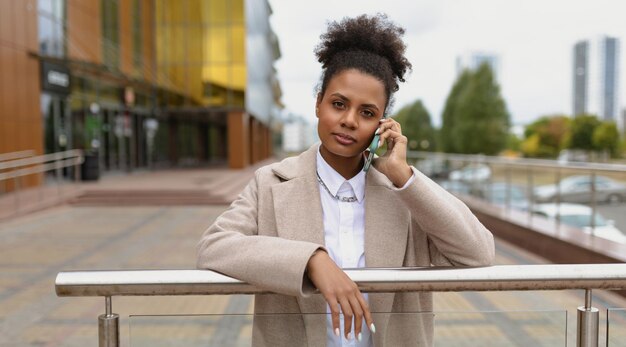 Una abogada estadounidense joven y seria hablando por teléfono móvil del concepto de una mujer fuerte y exitosa