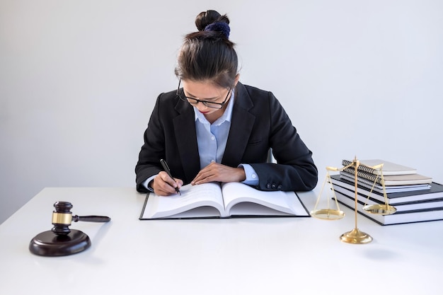 Foto abogado adulto medio leyendo un libro en el escritorio.