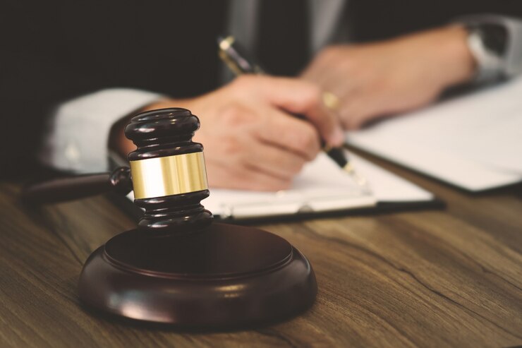Abogado de justicia / juez mazo trabajando con documentos legales en una sala de tribunal