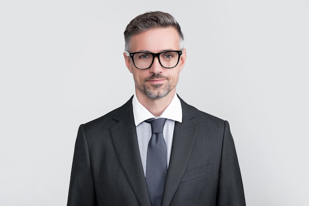 Un abogado maduro sonriente con gafas y traje de negocios.