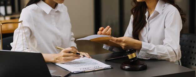 Abogado masculino que trabaja con papeles de contrato y mazo de madera en la mesa en la sala de justicia y el concepto de juez de la corte de abogados