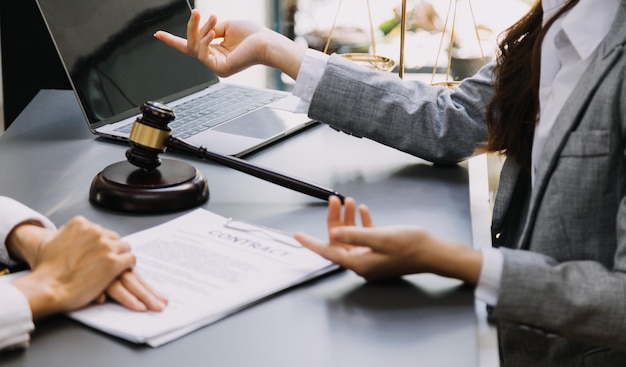 Abogado masculino que trabaja con papeles de contrato y mazo de madera en la mesa en la sala de justicia y el concepto de juez de la corte de abogados