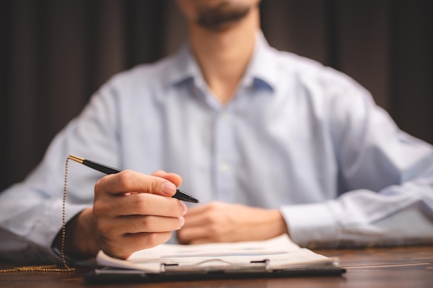 Foto abogado de negocios concepto de aprobación de documentos empresario profesional que usa un bolígrafo para firmar la firma para la aceptación del acuerdo un contrato de papeleo o acuerdo financiero en una oficina moderna