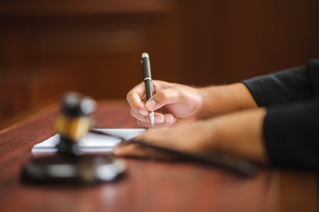 Abogado sosteniendo una pluma para escribir casos en la sala de audiencias