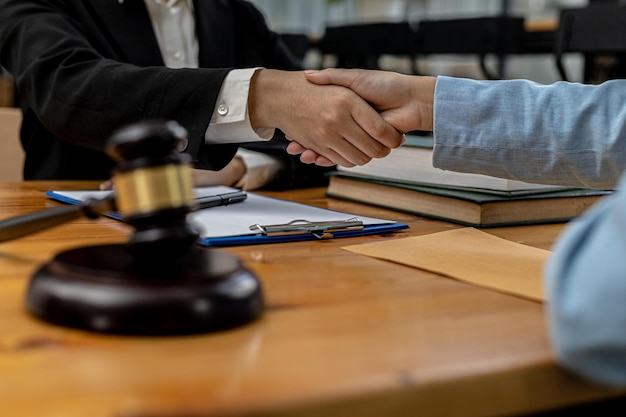 Foto los abogados dan la mano a los clientes que vienen a testificar en caso de malversación de fondos de socios comerciales que invierten conjuntamente en el negocio. el concepto de contratar un abogado para procedimientos legales.