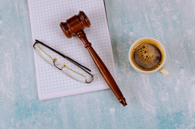 Abogados Juez escritorio con jueces de madera martillo una taza de café, cuaderno de gafas de lectura