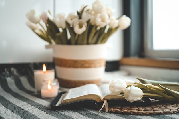 Abra a Bíblia com flores e velas em uma aconchegante casa interior Christian bela fotografia matinal