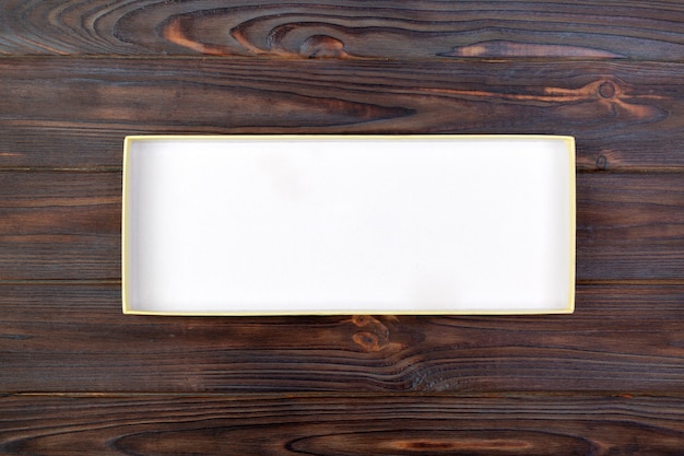 Abra a caixa branca do cartão em uma tabela escura, fundo de madeira.