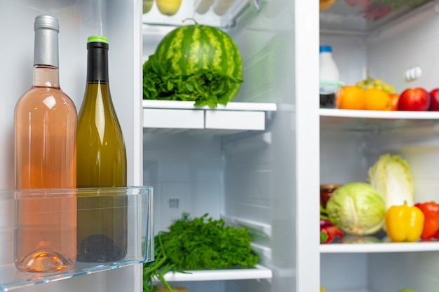 Abra a geladeira cheia de frutas, vegetais e bebidas