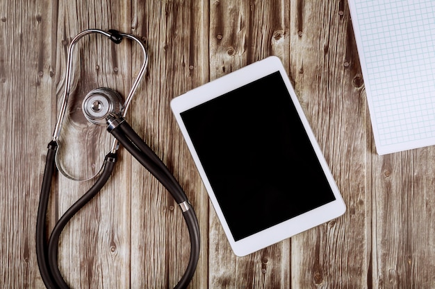 Abra el cuaderno blanco en blanco con estetoscopio de equipo médico de medicina en la tableta digital