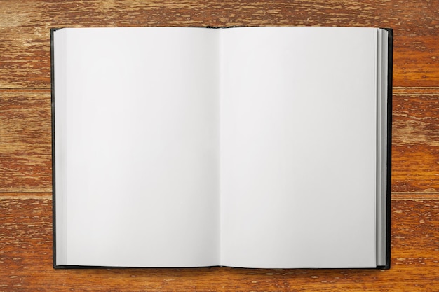Foto abra el cuaderno en blanco en un escritorio de madera