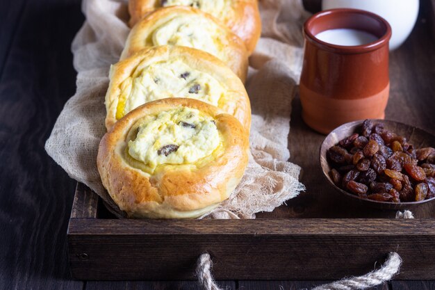 Abra las empanadas (bollos) con requesón y pasas.