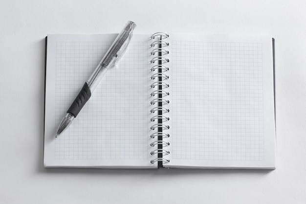 Abra o caderno e a caneta em uma foto de fundo branco com espaço de cópia