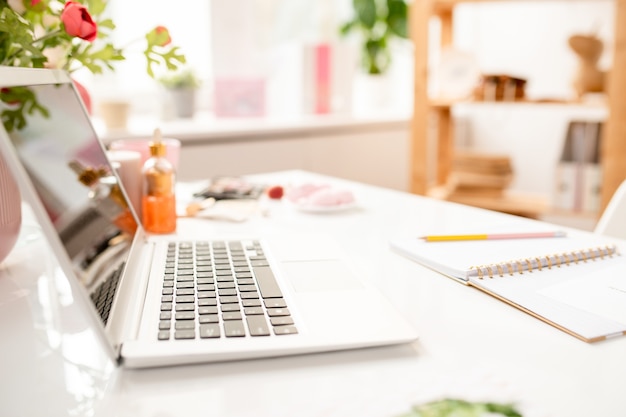 Abra o laptop e o notebook na mesa do designer de interiores contemporâneo ou gerente dentro do escritório