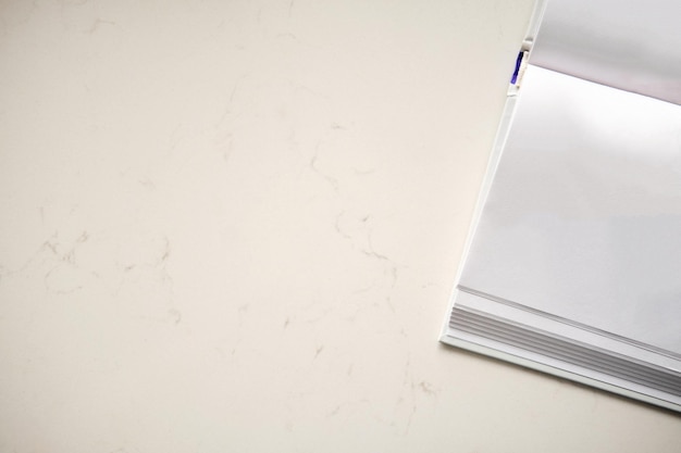 Foto abra o livro de capa dura com páginas brancas em branco na mesa de pedra copie a vista superior do fundo do espaço