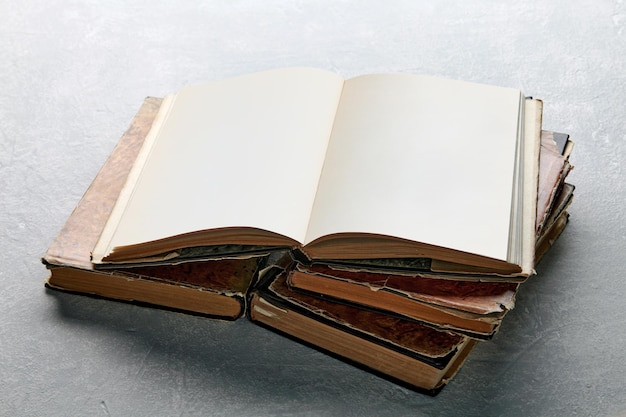 Abra o livro ou caderno vintage em uma super jaqueta em uma pilha de livros velhos e gastos em uma mesa de concreto leve