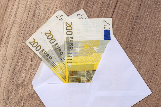 Abra un sobre con billetes en euros sobre la mesa