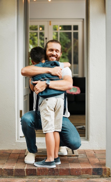 Abraçando o amor e o cuidado entre um pai e filho se unindo ao ar livre em sua casa de família Homem positivo e sorridente amoroso abraçando seu garotinho Macho feliz mostrando sua afeição infantil enquanto brinca