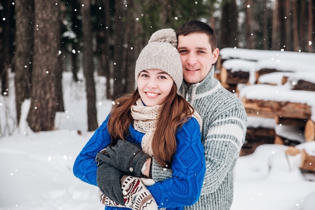 Abraçando o casal olhando com sorrisos em winter park