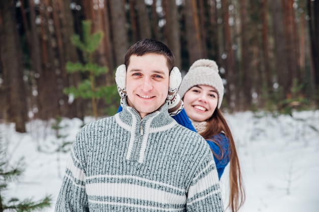 Abraçando o casal olhando com sorrisos em winter park