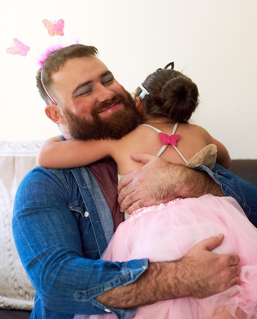 Abraçando seu lado feminino por amor à filha foto de uma garotinha carinhosa brincando de se fantasiar com o pai em casa