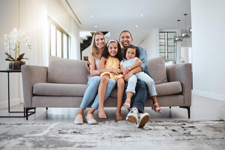 Foto abraço de amor de retrato e família no sofá na sala de estar sorrindo e criando laços de apoio e feliz mãe pai e meninas se abraçando ou abraçando no sofá se divertindo e aproveitando o tempo juntos