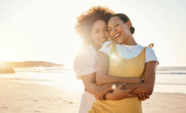 Abraço de retrato e casal lgbt na praia juntos para romance ou relacionamento em um encontro Modelo de pôr do sol e uma mulher gay com sua namorada lésbica à beira-mar ou oceano para sua lua de mel