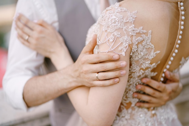 Abraço do noivo e da noiva em um close de vestido de renda