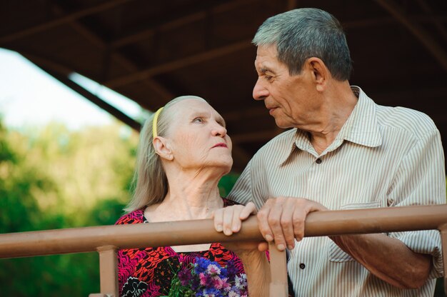 Abraço e beijo do casal de velhos em um parque em um dia ensolarado.