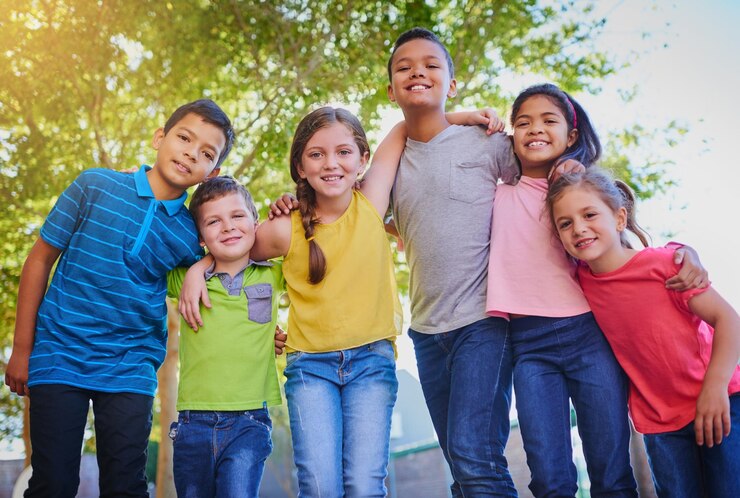 Foto abraço feliz e retrato de crianças no parque para brincar ligação e diversão juntos ao ar livre diversidade juvenil e jovens meninos e meninas na natureza para aventura infantil e amizade no playground