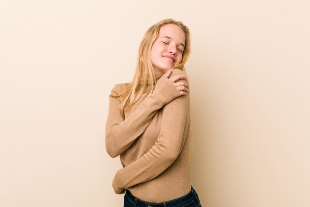 Abraços de mulher adolescente bonito e natural, sorrindo despreocupado e feliz.