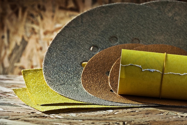 Abrasivos cuadrados redondos y hojas laminadas de papel de lija sobre madera contrachapada